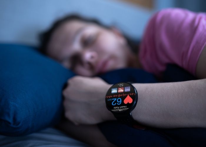 Mulher dormindo, com um smartwatch que controla os sono