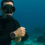 10 Melhores Smartwatches à Prova d'Água em 2025 - Homem com roupa de mergulho no fundo do mar exibindo seu smartwatch